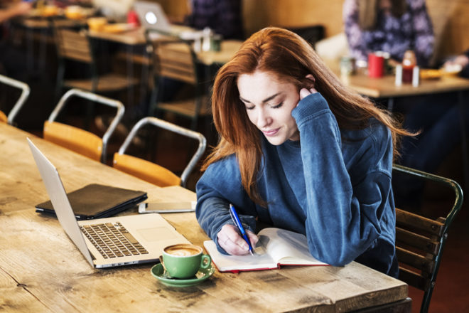 若い女性が机でパソコン作業をしている