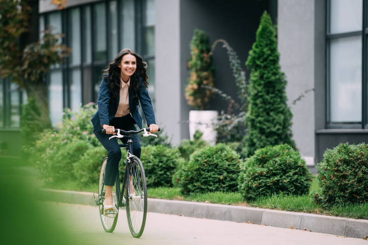 スーツの女性が自転車に乗っている