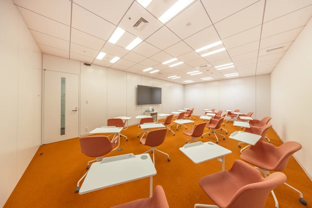 創造力を掻き立てる効果が期待できるオレンジを取り入れた学校のような会議室