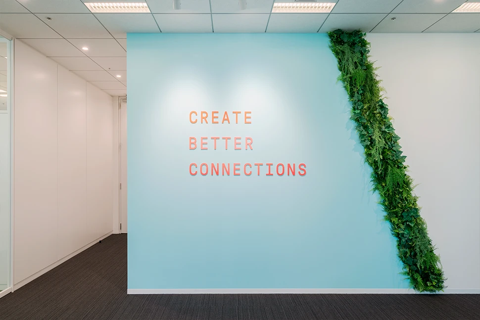 スローガンとグリーン装飾が美しい廊下壁面