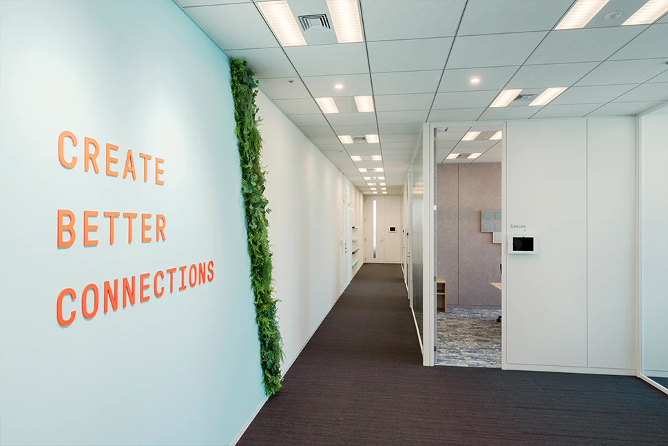 廊下の壁に掲げられたメッセージとグリーンのアクセント