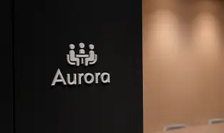 ウォームカラーの壁とロゴが特徴の会議室前エリア