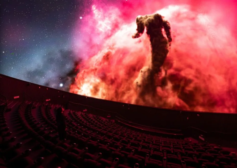LEDドームに星雲の映像が映し出されたプラネタリウムの客席