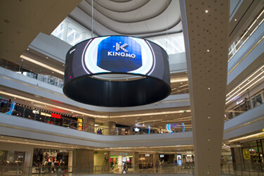 ショッピングモールの中央に設置した曲面LEDディスプレイに会社ロゴが映し出されている